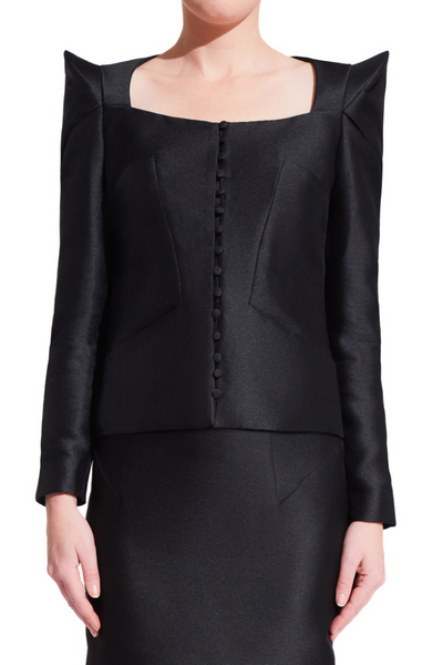 Women's black formal jacket with long sleeves and centered front buttons. Oragami style geometric design with padded shoulders