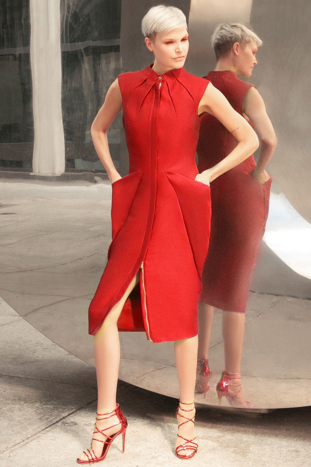 Midi red cocktail dress with gold tone zipper and adjustable front slit. Oragami style geometric design with inbuilt pockets 